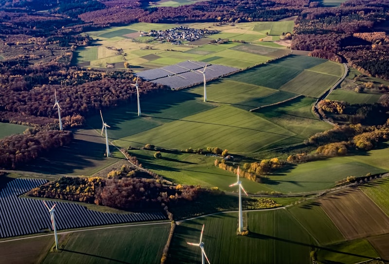 Turbinas eólicas e painéis solares numa paisagem rural na Alemanha — a produção de energia limpa disparou, mas a rede não consegue escoá-la