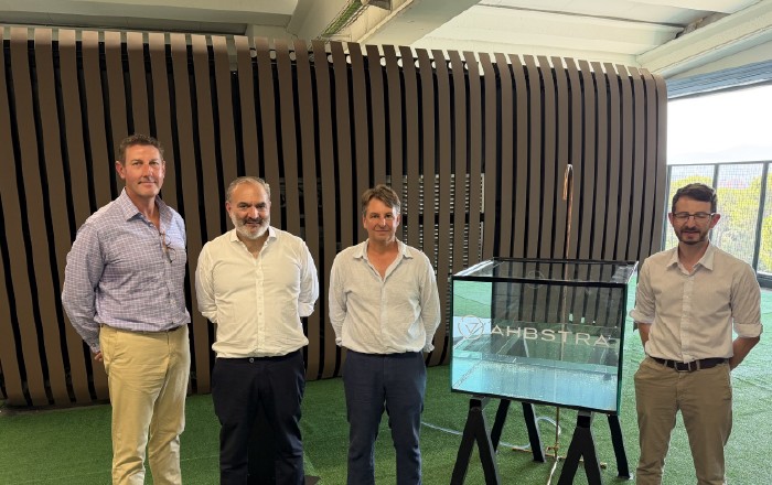 Quatro membros das equipas Ahbstra e Promethean junto de um expositor transparente no lançamento da ARK