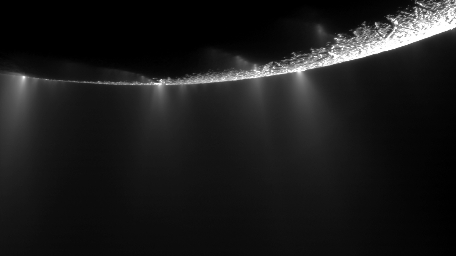 Plumas de gelo e vapor visíveis sobre as fracturas do pólo sul de Enceladus numa imagem real da missão Cassini