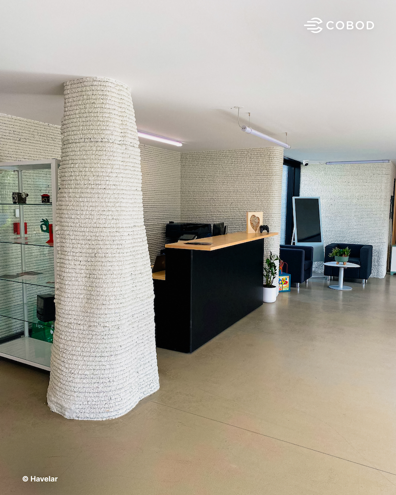 Impressora COBOD BOD2 a imprimir as paredes de betão do Ecocentro de Perafita, em Matosinhos, com a textura estratificada característica da construção 3D visível
