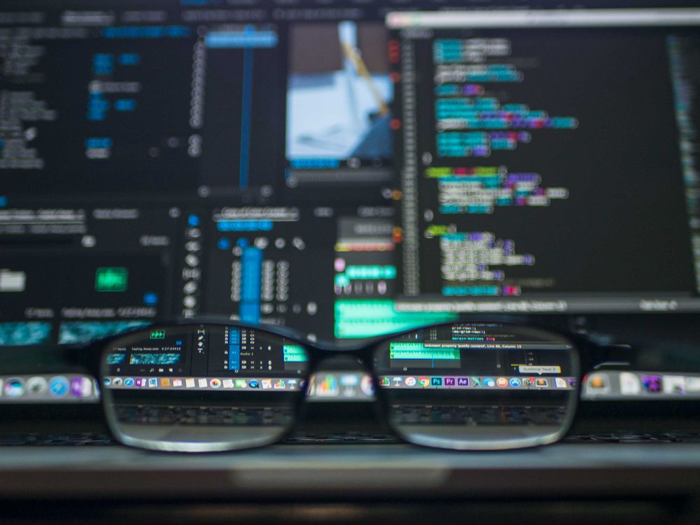 Ecrã de computador com linhas de código e símbolos de cadeado representando um ciberataque ou invasão de sistema