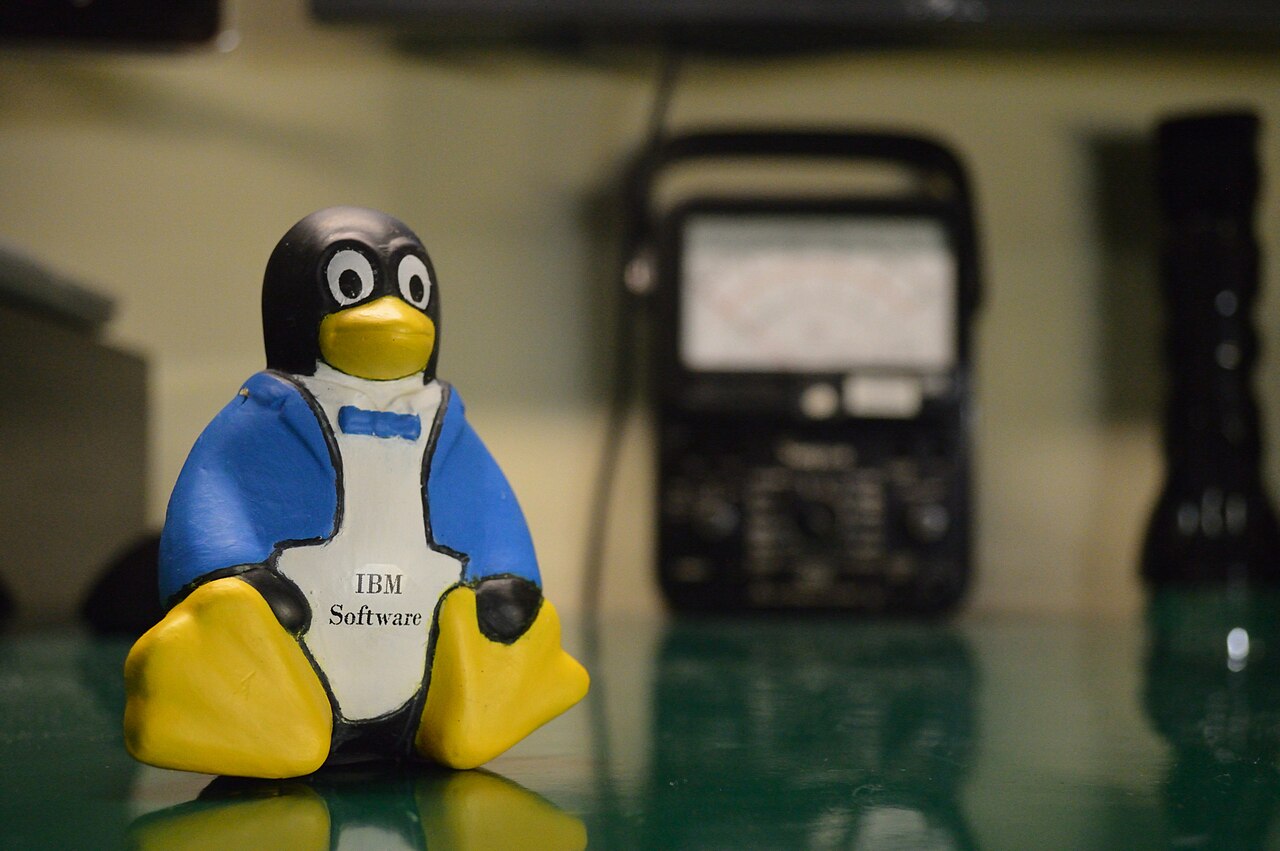 Mascote Tux do Linux com casaco e camisa promocional da IBM
