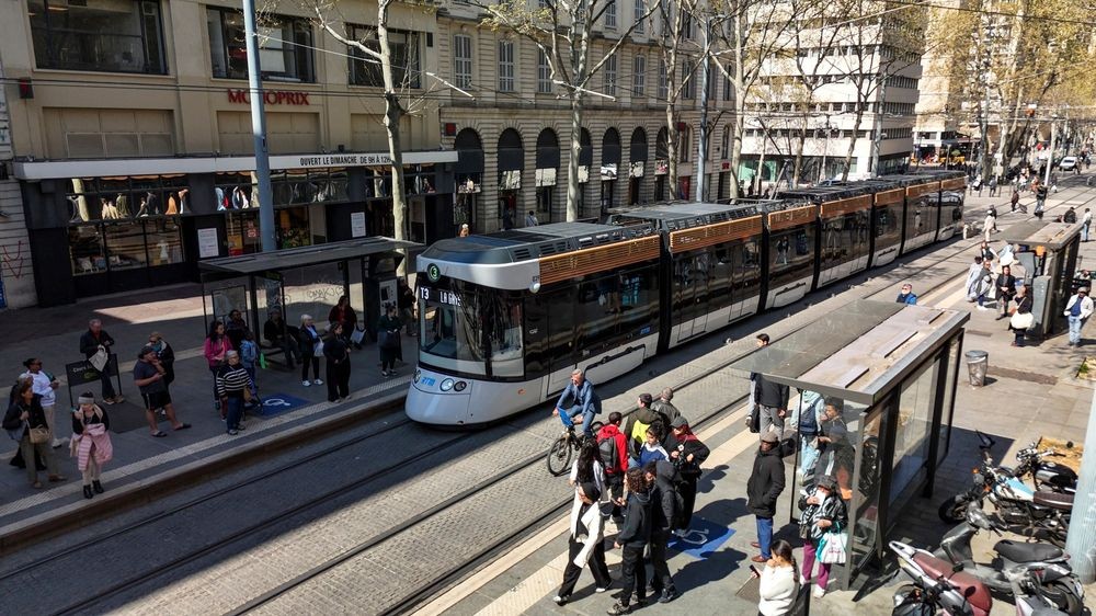 Composição CAF em circulação numa avenida urbana com paragens de passageiros