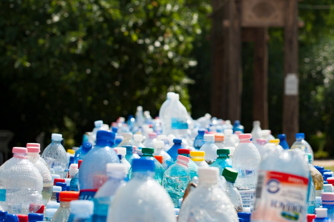 Montanha de garrafas de plástico PET descartadas, ilustrando o problema global da poluição por plásticos e microplásticos