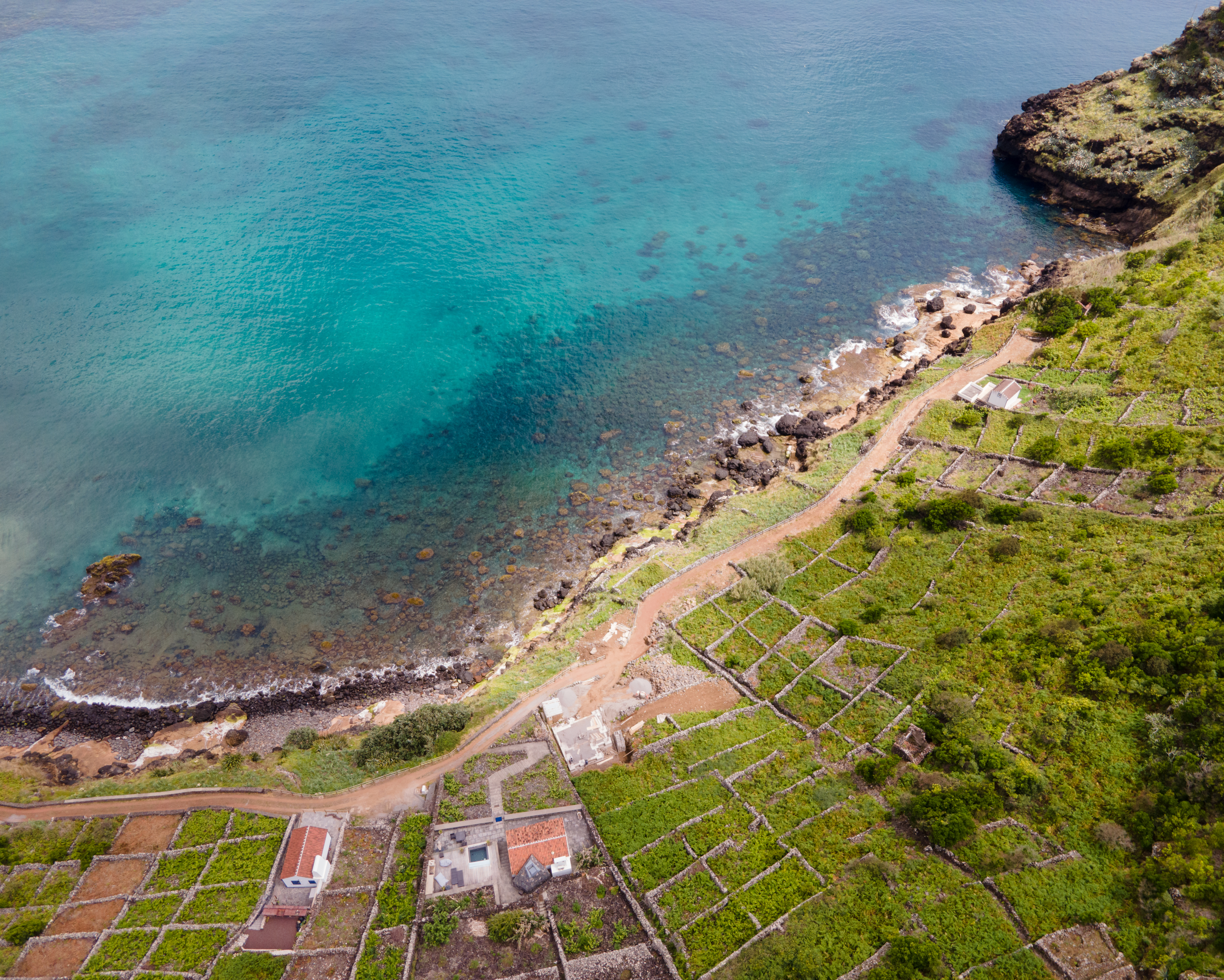 Vista aérea da ilha de Santa Maria, Açores, com a placa de betão do centro de lançamento de Malbusca e o oceano Atlântico em fundo