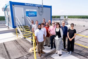 Grupo de investigadores junto da Quantum Lighthouse numa instalação no topo de um edifício
