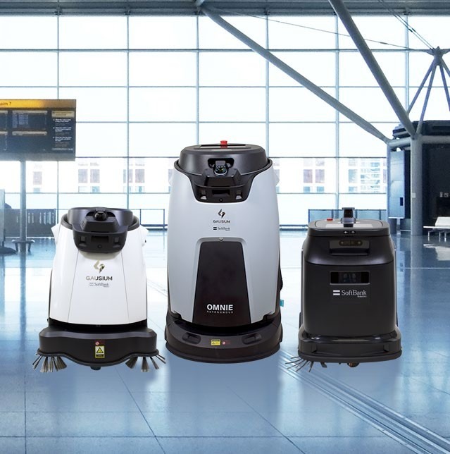 Três robôs autónomos de limpeza apresentados num ambiente com aparência de terminal aeroportuário