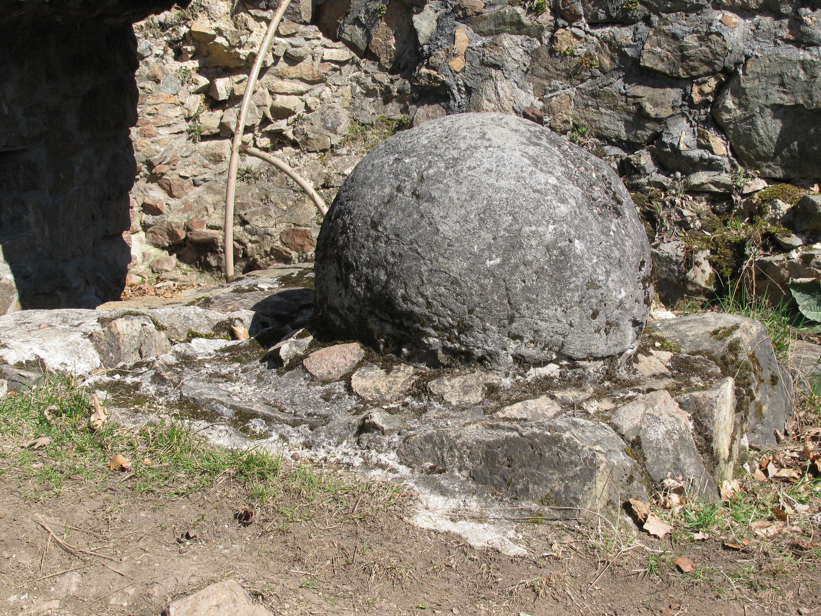 Grande bola de pedra junto às ruínas de Tannenberg, apresentada como projétil associado a um cerco medieval