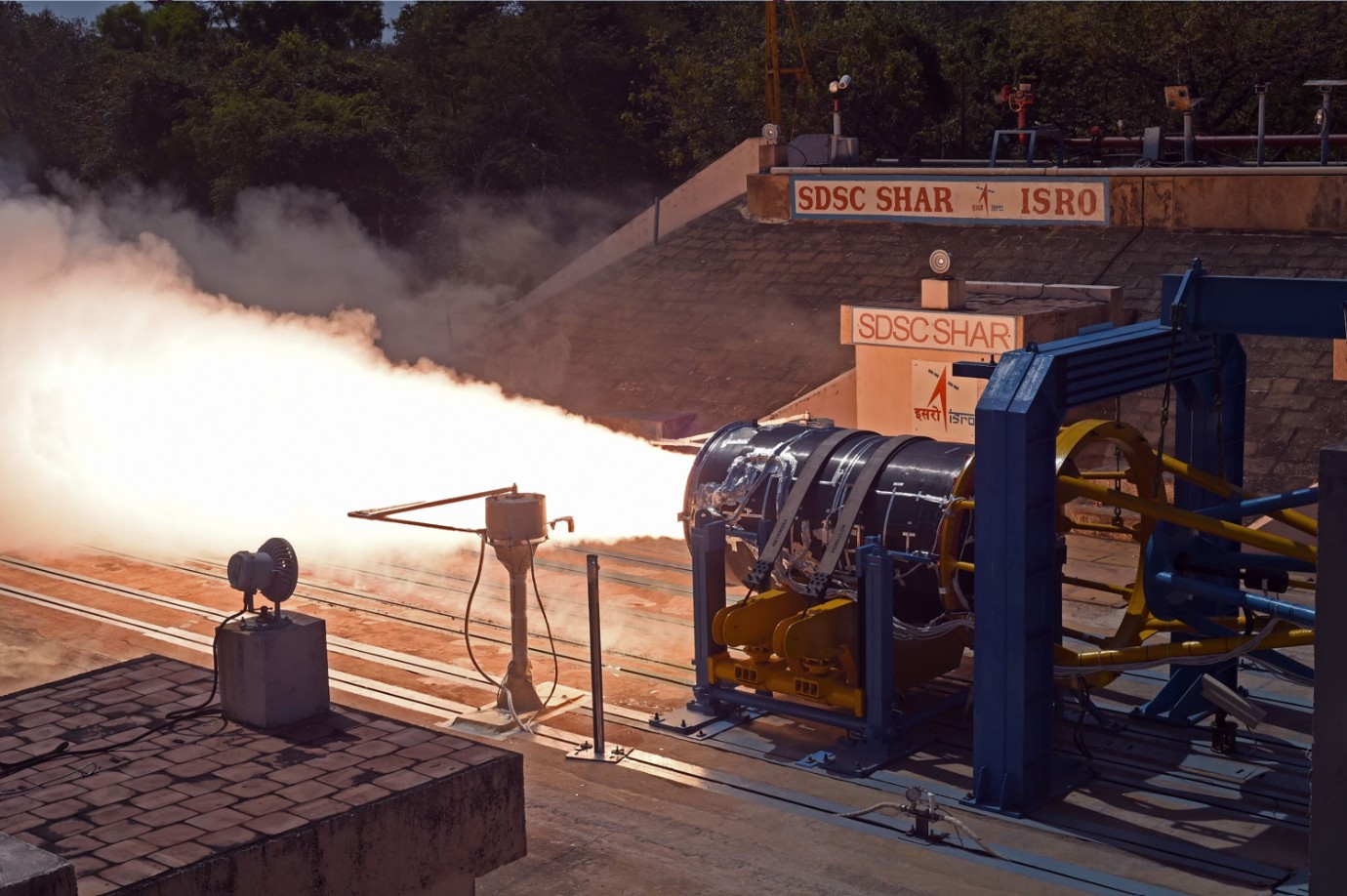 Teste de motor de foguetão em bancada no SDSC SHAR da ISRO, com chama intensa e suporte azul