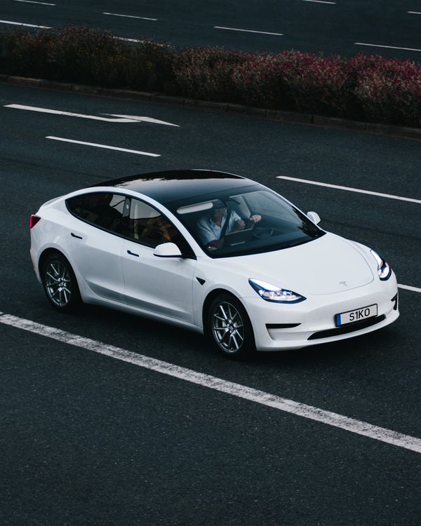 Tesla Model 3 branco numa estrada alemã — o modelo mais vendido da marca que liderou o recorde de entregas no 2º trimestre de 2026