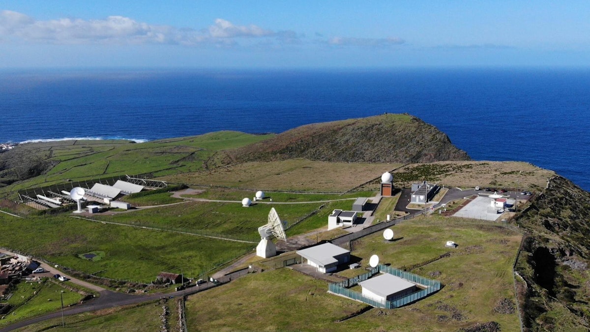 Antena parabólica no Teleporto de Santa Maria, Açores, com paisagem verdejante ao fundo