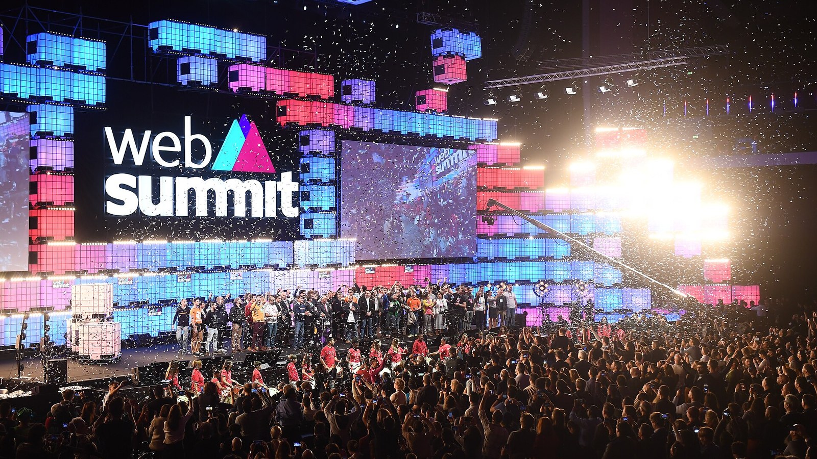 Palco Central do Web Summit na Altice Arena, em Lisboa, com o logótipo do evento, ecrãs coloridos e o público durante a noite de abertura de 2018