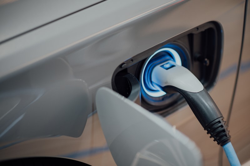 Porta de carregamento de um veículo elétrico com cabo ligado e anel LED azul — a tecnologia que depende do lítio e motiva a procura por extração mais sustentável