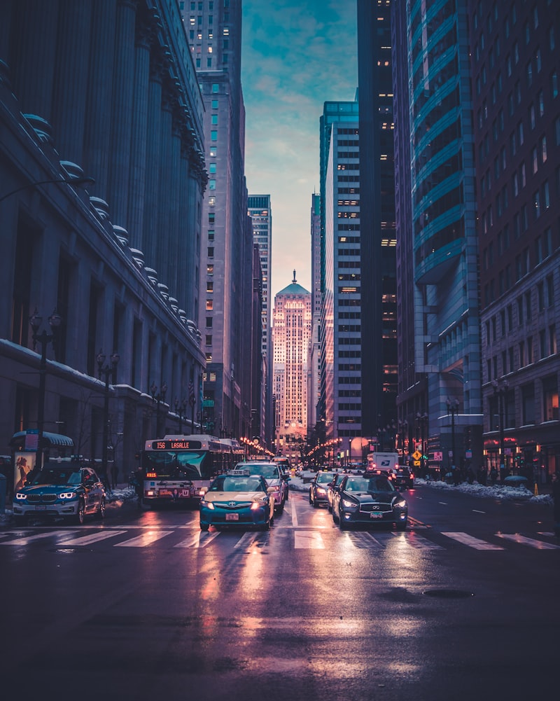 Avenida movimentada de uma cidade à noite, com arranha-céus iluminados e trânsito — o ambiente urbano onde as redes inteligentes e o everything-to-grid operam