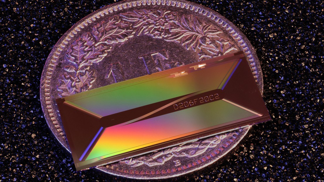 Chip fotónico da EPFL sobre uma moeda de 1 CHF para escala. ©2026 EPFL / Zheru Qiu
