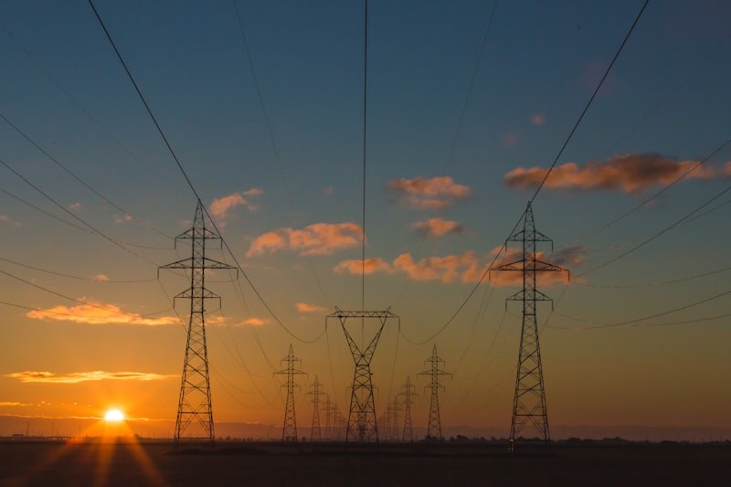 Postes de alta tensão contra o céu ao entardecer